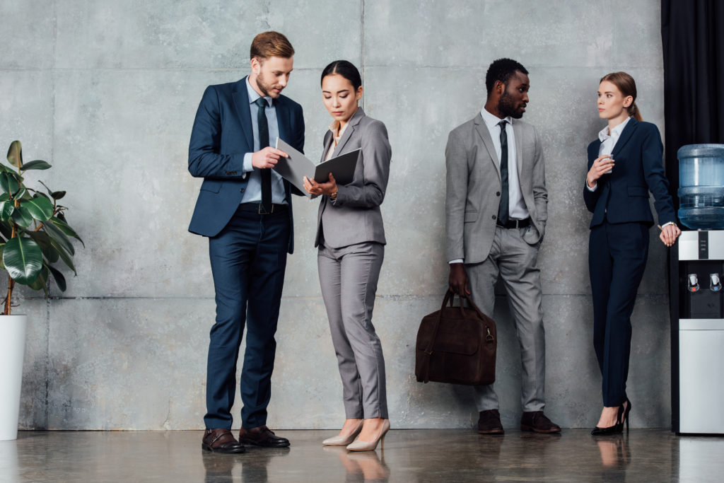 multi-ethnic businesspeople around water cooler