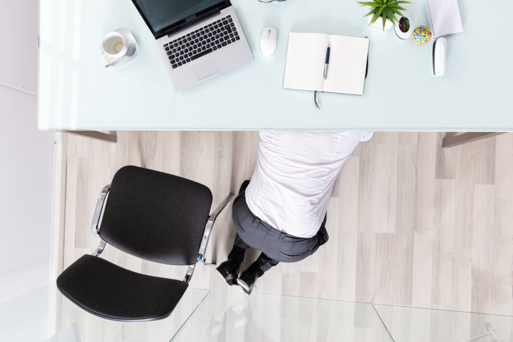 Business man hiding under desk